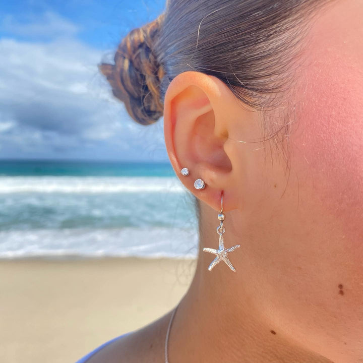 Starfish hook earrings in sterling silver worn on ears, beachy everyday style"