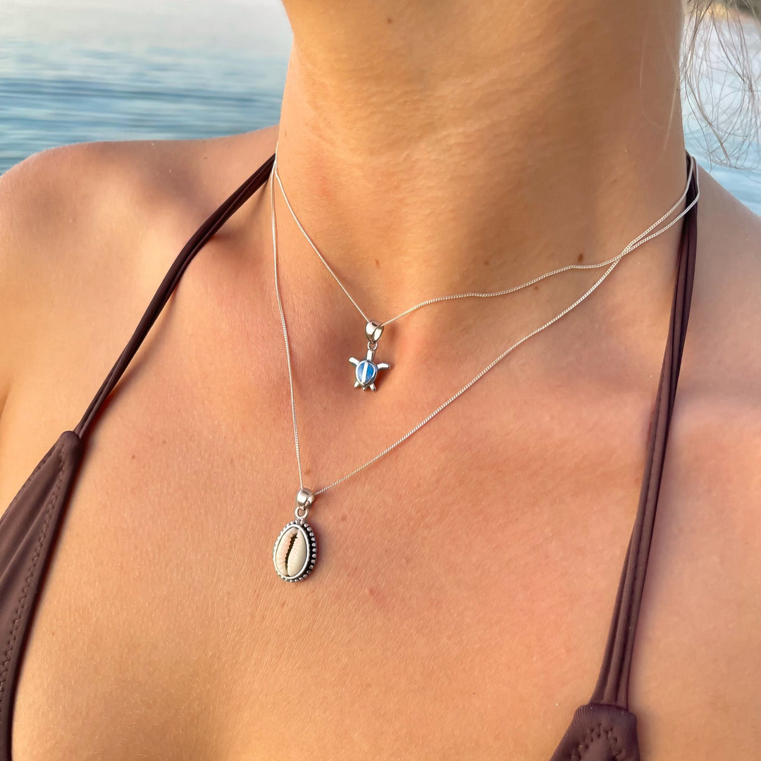 Blue opal turtle pendant necklace in sterling silver worn on model, ocean-inspired design