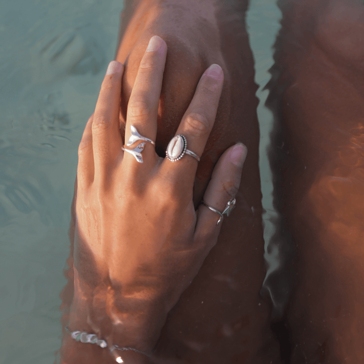 Sterling silver cowrie shell ring styled with ocean-themed ring stack