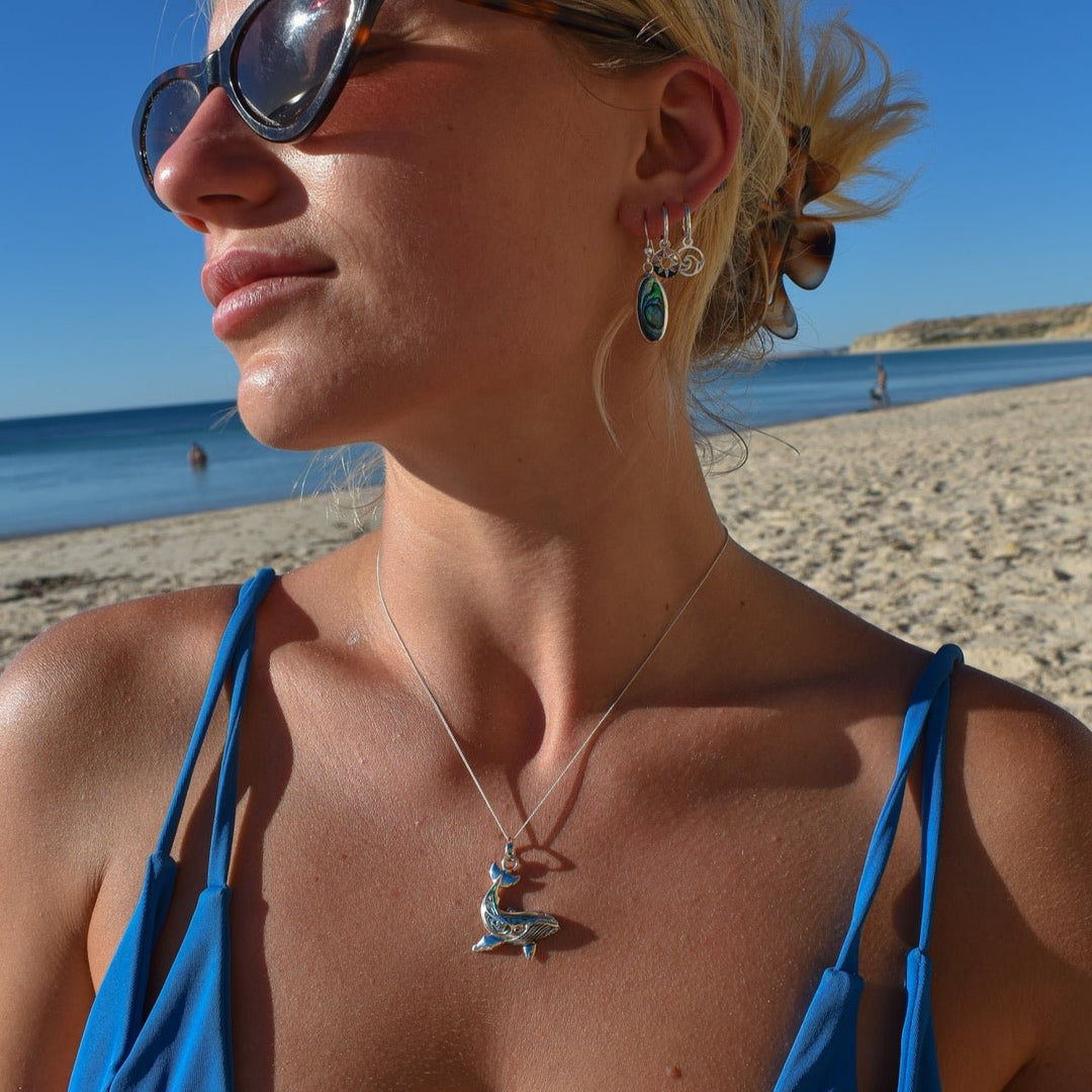 Mismatched hoop earrings with sun and wave charms styled with coastal jewellery