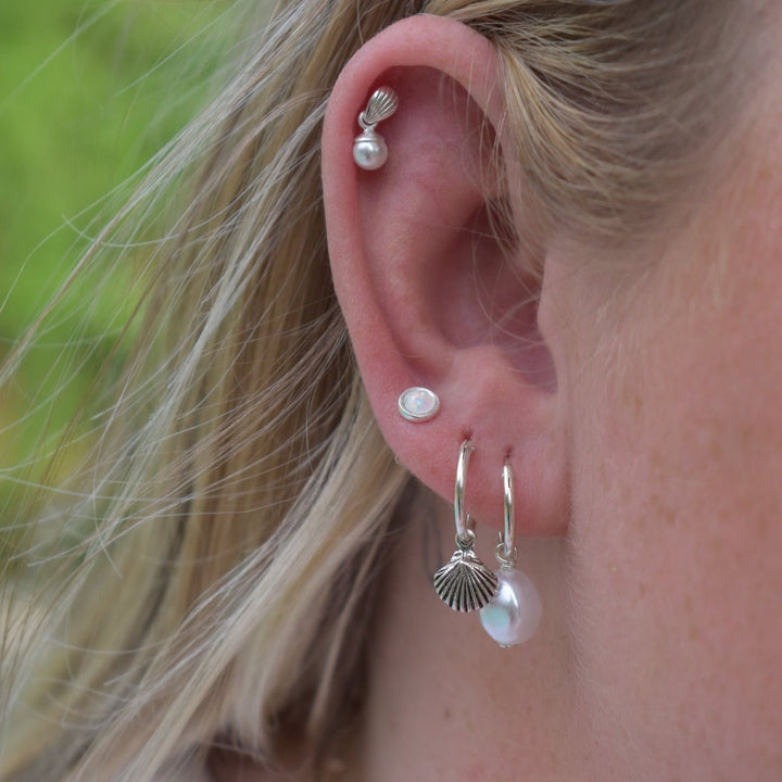 model wearing a shell and pearl ear stack 