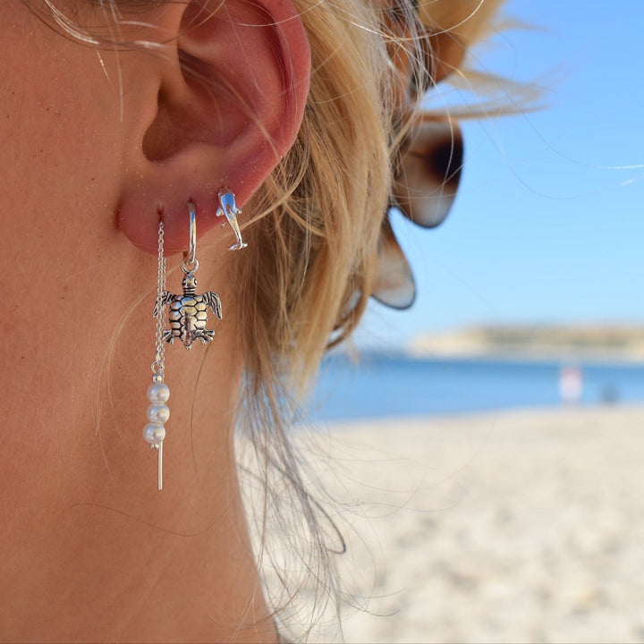Pearl threader earrings in sterling silver worn on ears, delicate beach-style jewellery
