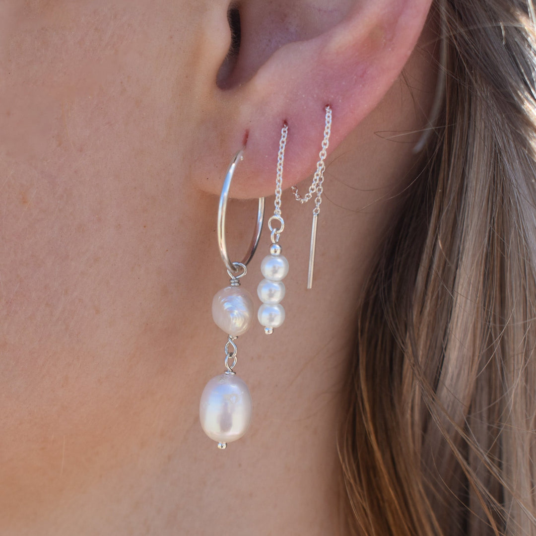 Sterling silver threader earrings with pearls styled with ocean-inspired accessories