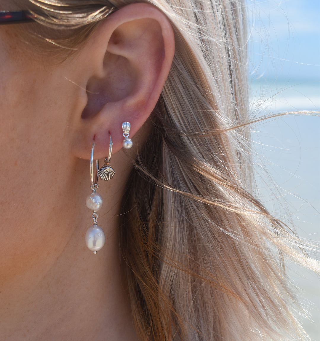 Close-up of waterproof pearl stud earrings in silver