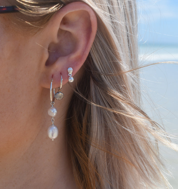 Close-up of waterproof pearl stud earrings in silver