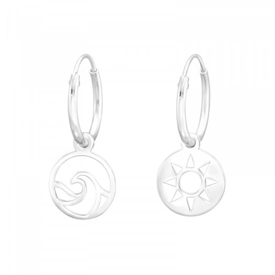 Sterling silver mismatched hoop earrings with wave and sun charms on white background