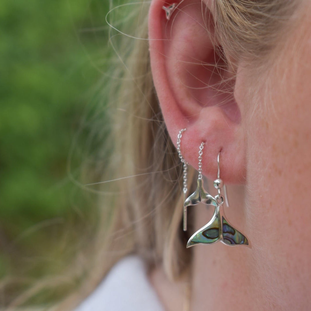 Whale tail threader earrings in sterling silver worn on ears, minimal ocean design